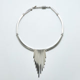 Silver fringe necklace on a light gray background
