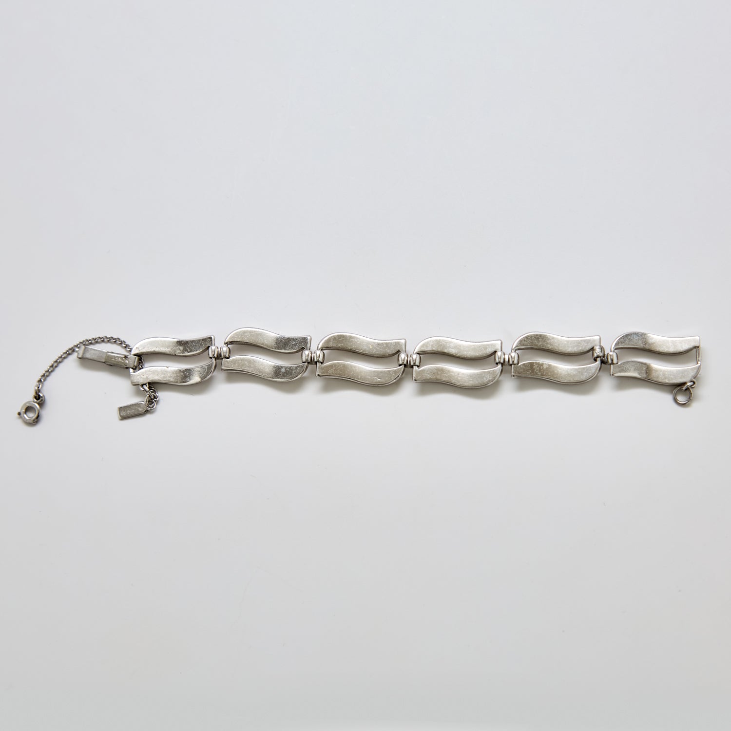 Back view of vintage Monet silver-tone wave link bracelet showing clasp detail and polished curved link design.
