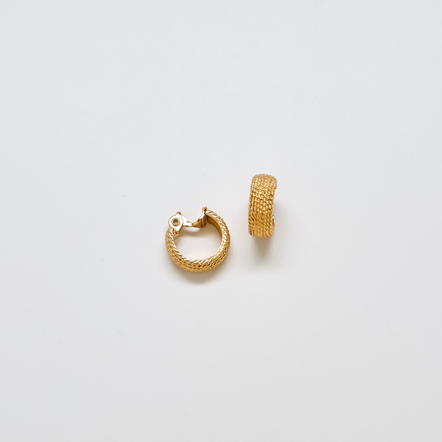 Pair of vintage Monet gold-tone hoop earrings with textured woven finish and clip-back closure