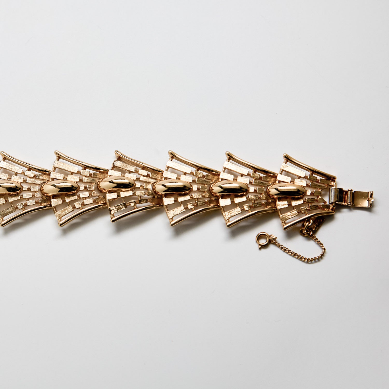 Gold bracelet on a light gray background