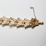 Gold bracelet on a light gray background