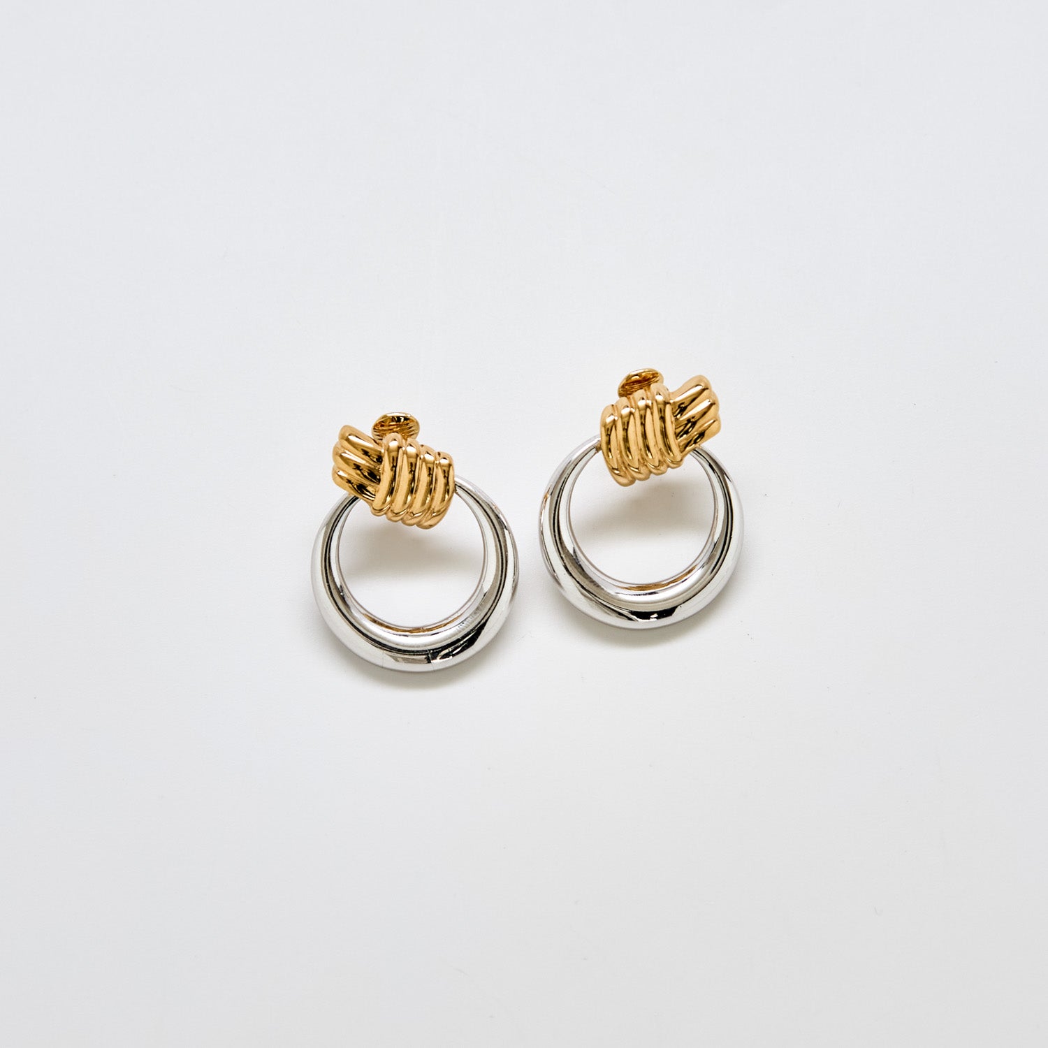 Pair of vintage Monet two-tone door knocker earrings with gold knot tops and silver-tone circular drops