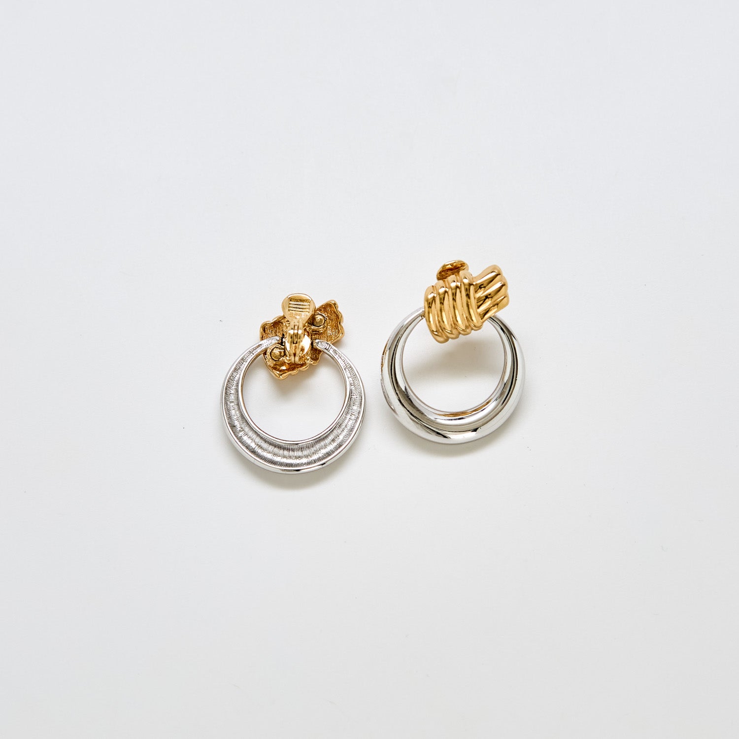Back view of vintage Monet two-tone earrings showing clip-back closure and mixed metal finish.
