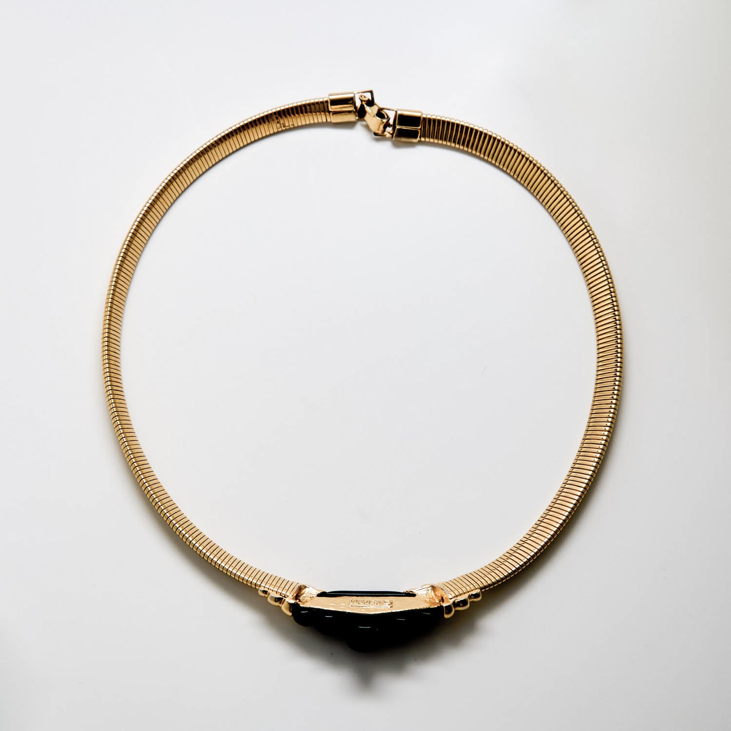 Gold necklace on a light gray background