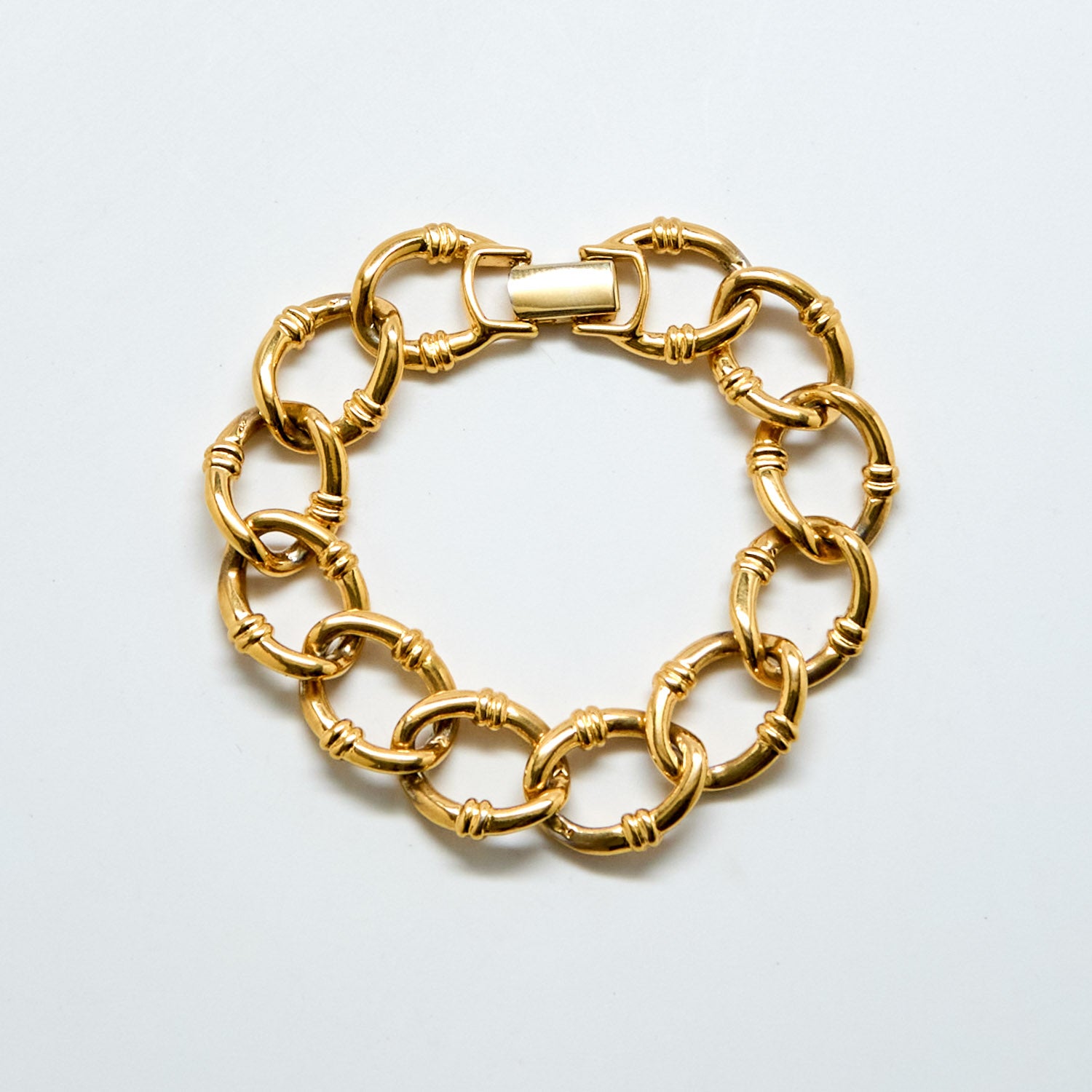 Gold chain bracelet on a light gray background