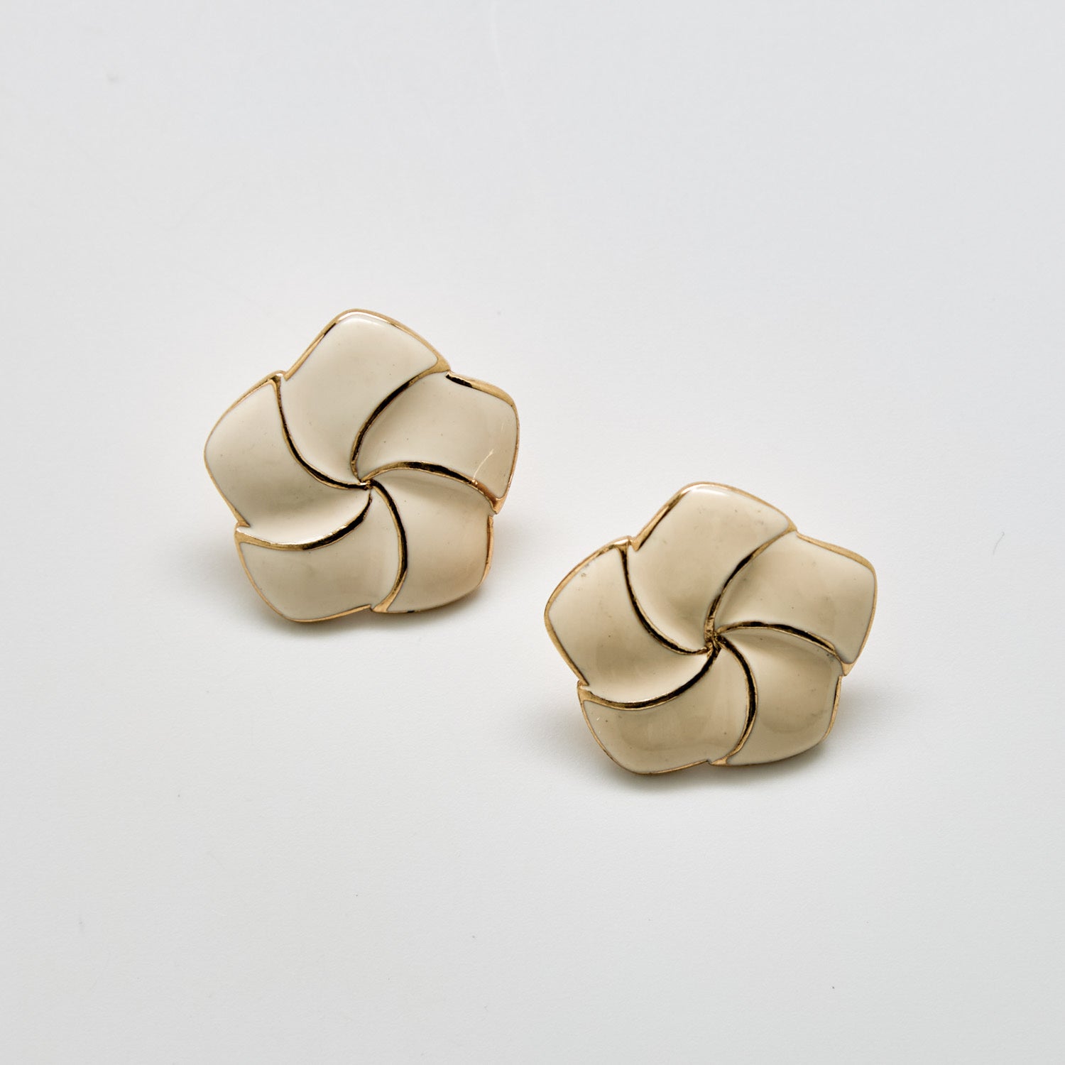 Pair of beige floral earrings on a light gray background
