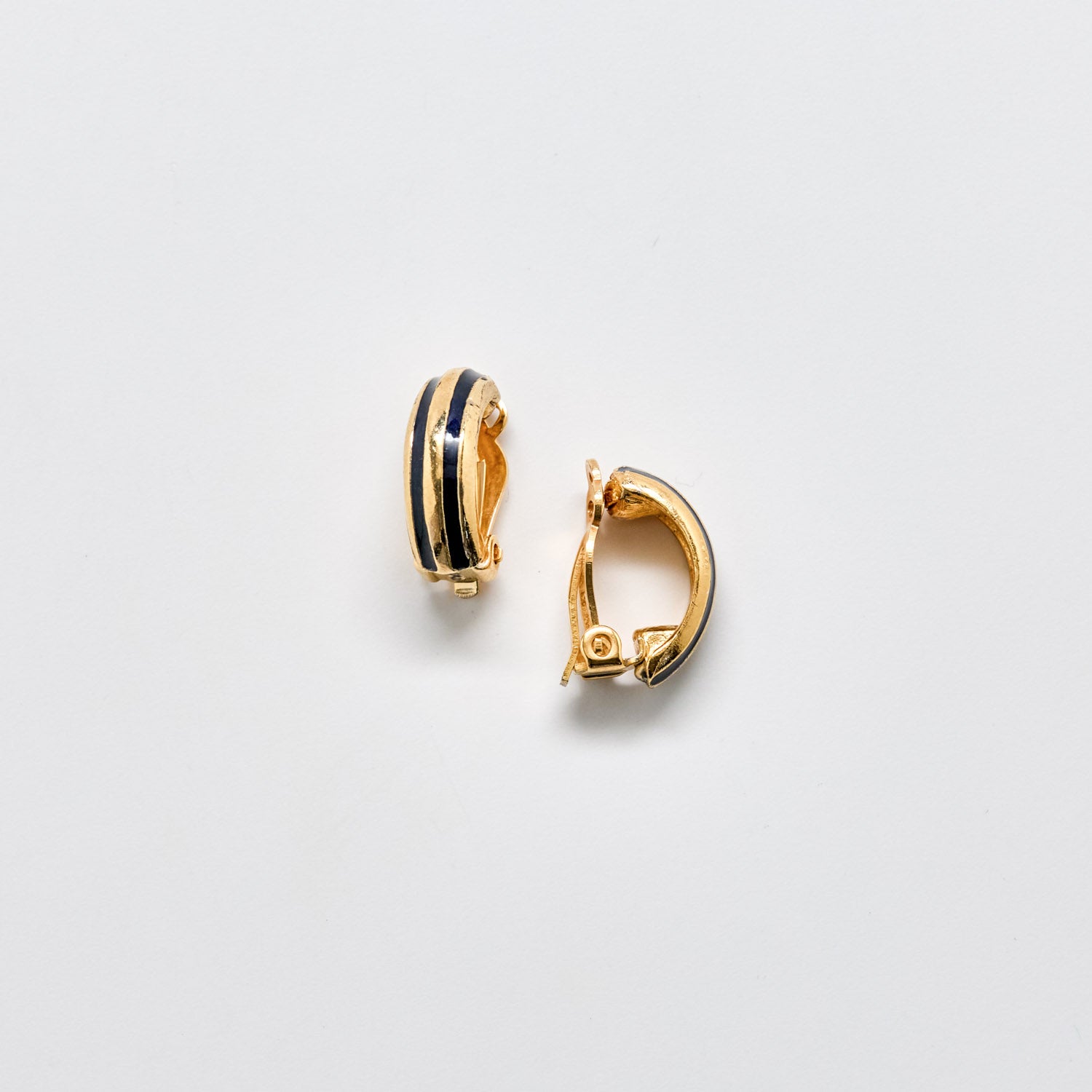 Gold hoop earrings with navy accents on a light gray background