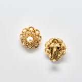 Gold earrings with pearl-like stones on a light gray background