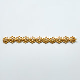 Gold bracelet on a light gray background