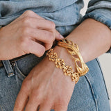 Person wearing a gold bracelet on a denim background