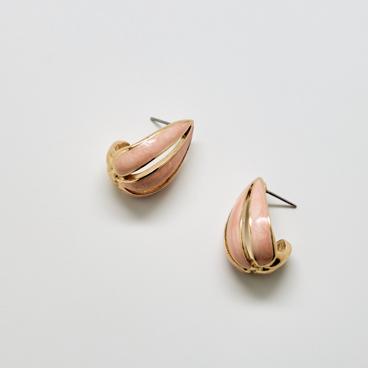 Pair of pink and gold earrings on a light gray background