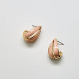 Pair of pink and gold earrings on a light gray background