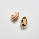 Gold and pink earrings on a light gray background