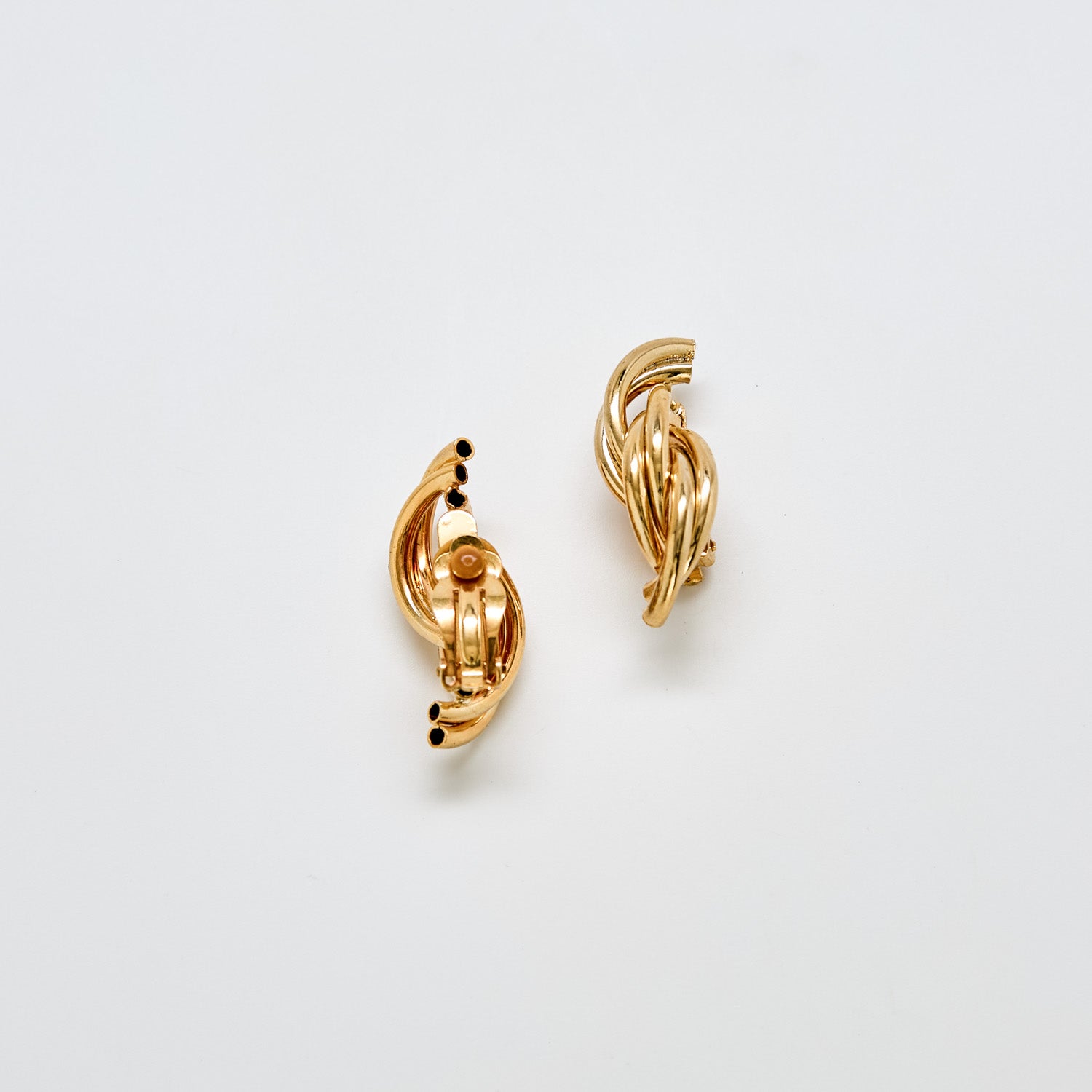 Back view of unsigned vintage gold-tone twisted hoop earrings showing clip-back closure.