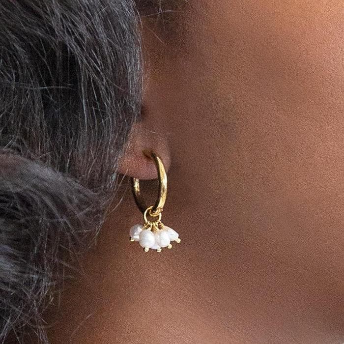 Gold hoop with a cluster of small freshwater pearls worn on the ear