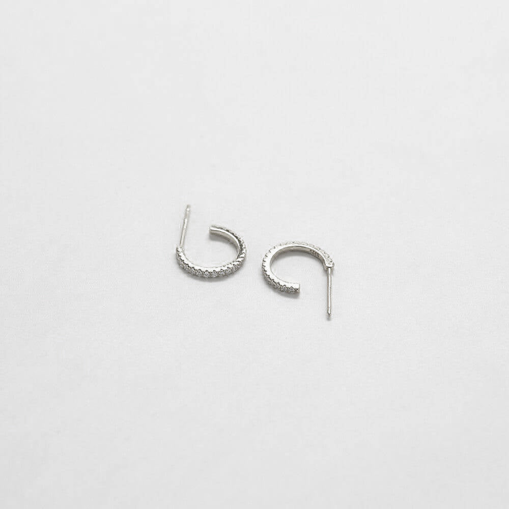 Pair of silver hoop earrings on a light gray background