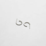 Pair of silver hoop earrings on a light gray background