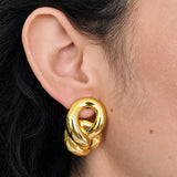 Vintage gold-tone sculptural knot clip-on earrings — modeled
