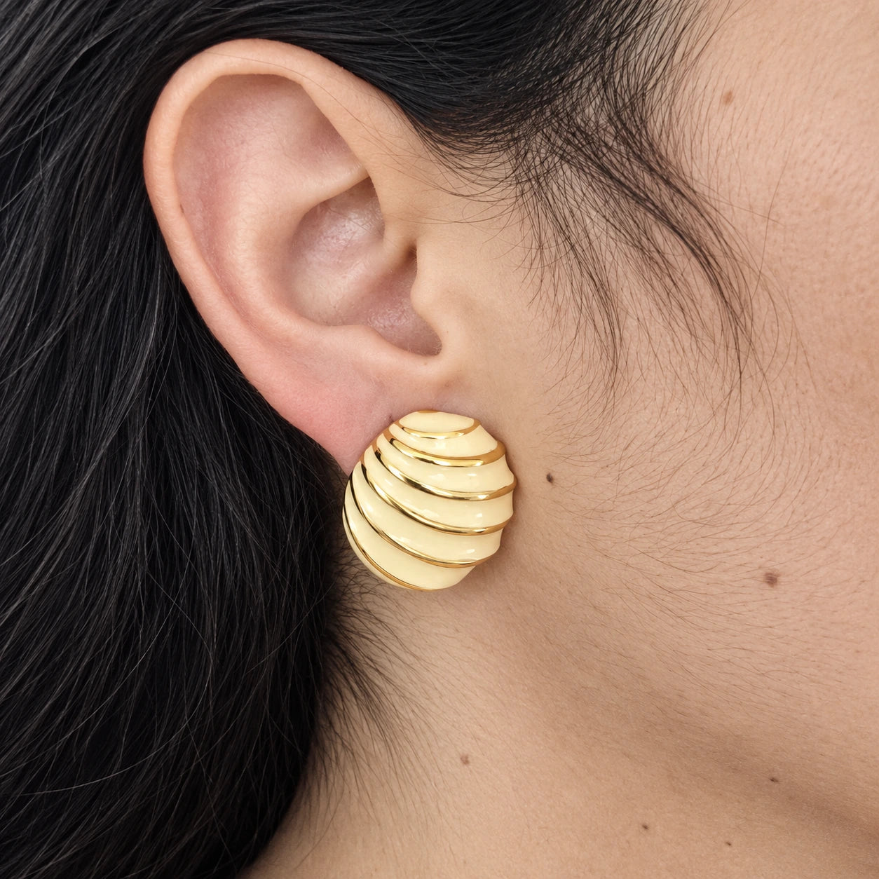 Vintage Napier ivory stripe shell earring — on-ear view
