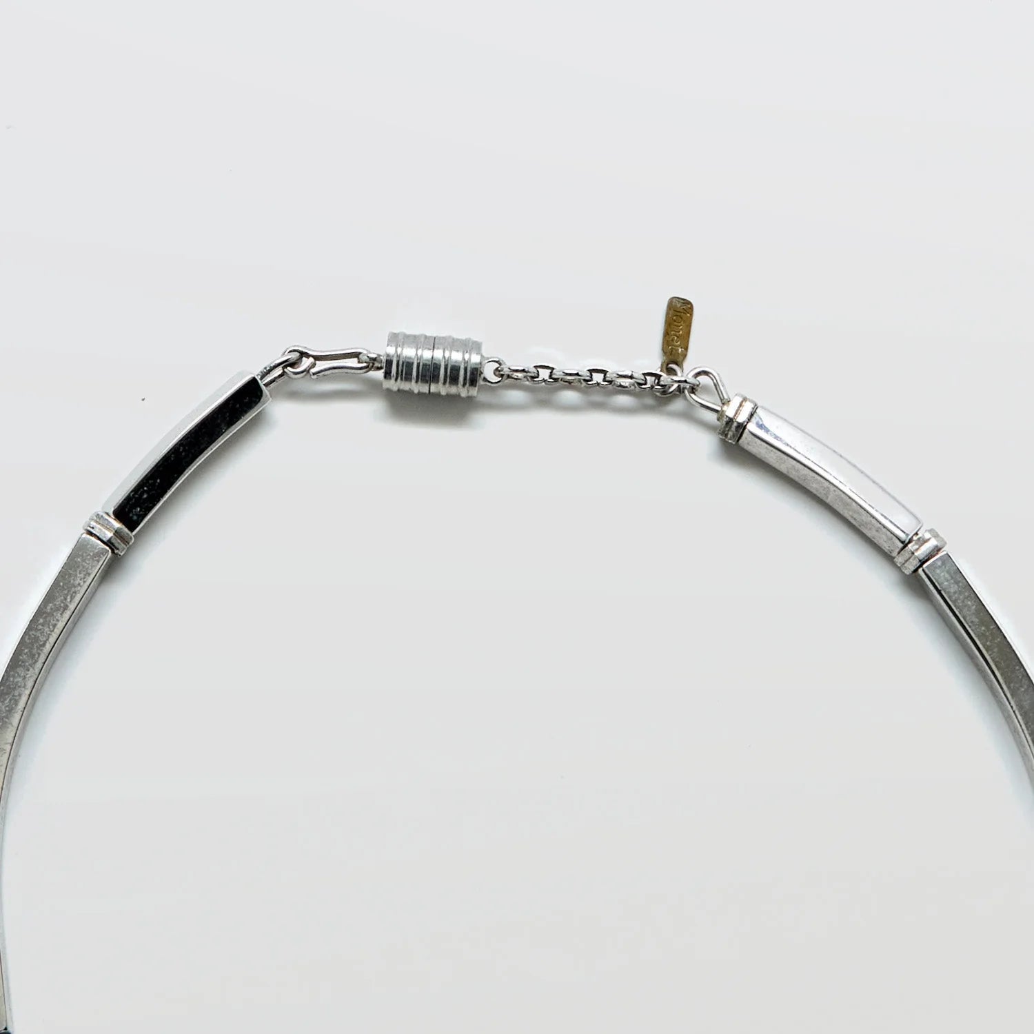 Close-up of the vintage Monet silver-tone fringe collar necklace clasp on a light gray background