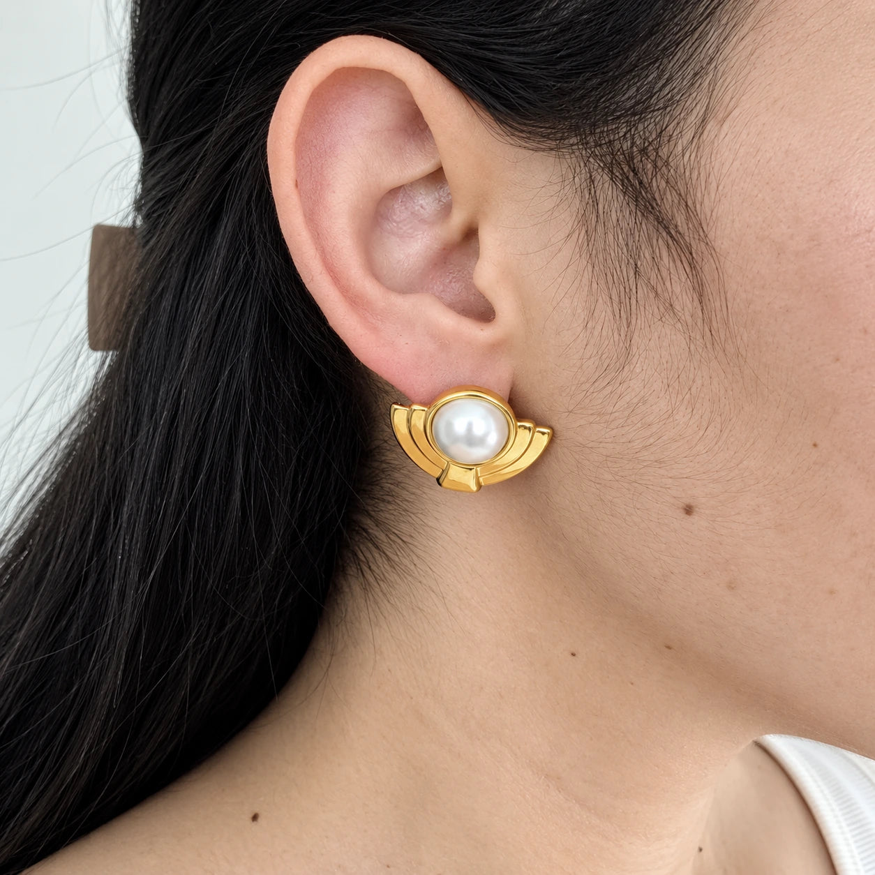 Vintage Monet pearl-look Deco stud earrings — on-ear view