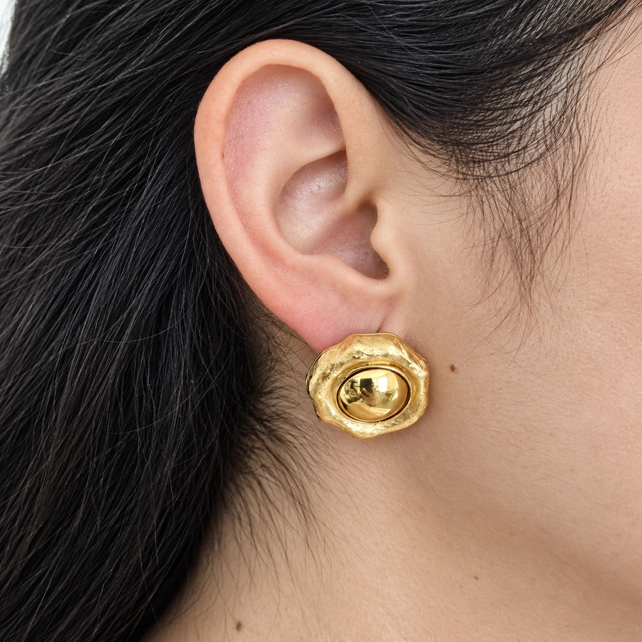 Vintage Monet raised dome stud earring — on-ear view