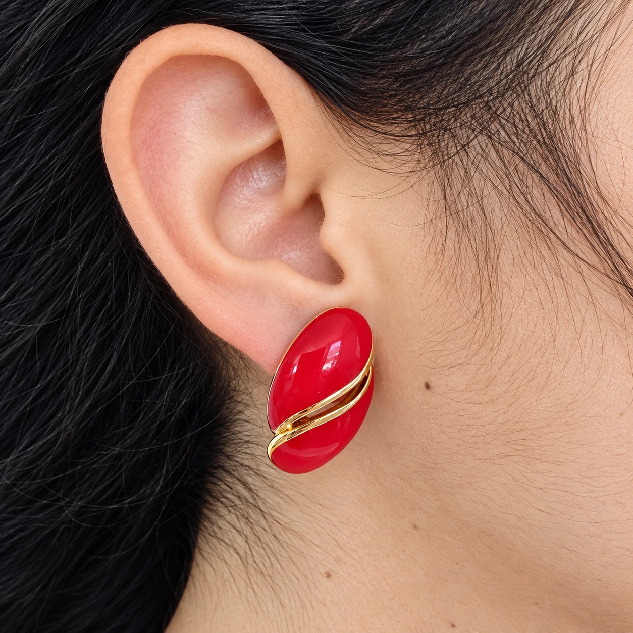 Vintage Monet red oval clip-on earring — on-ear view