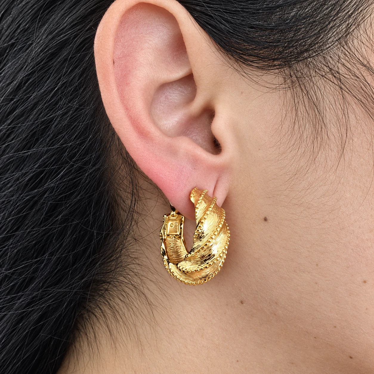 Vintage Monet scalloped twist hoop earrings — on-ear view