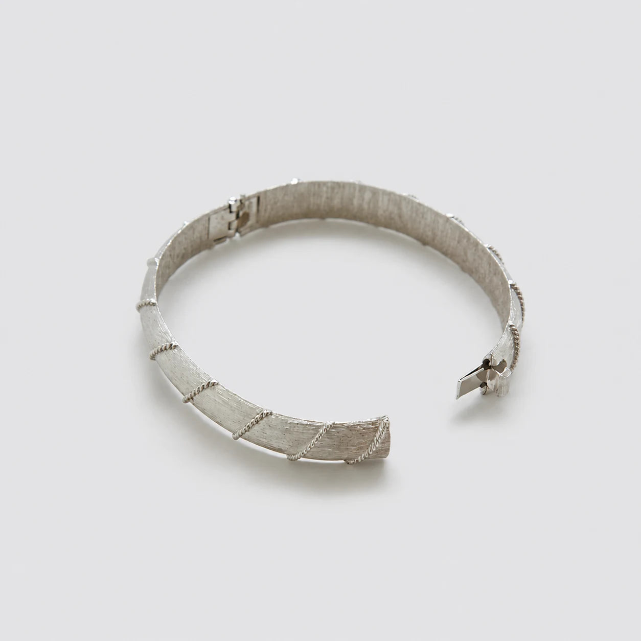 Vintage silver-tone textured hinged bangle — open clasp view