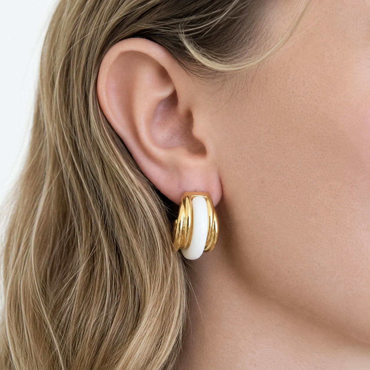 Vintage white enamel hoop earrings worn on model — front view
