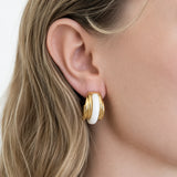 Vintage white enamel hoop earrings worn on model — front view