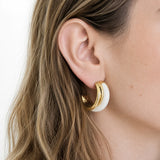 Vintage white enamel hoop earrings worn on model — side view
