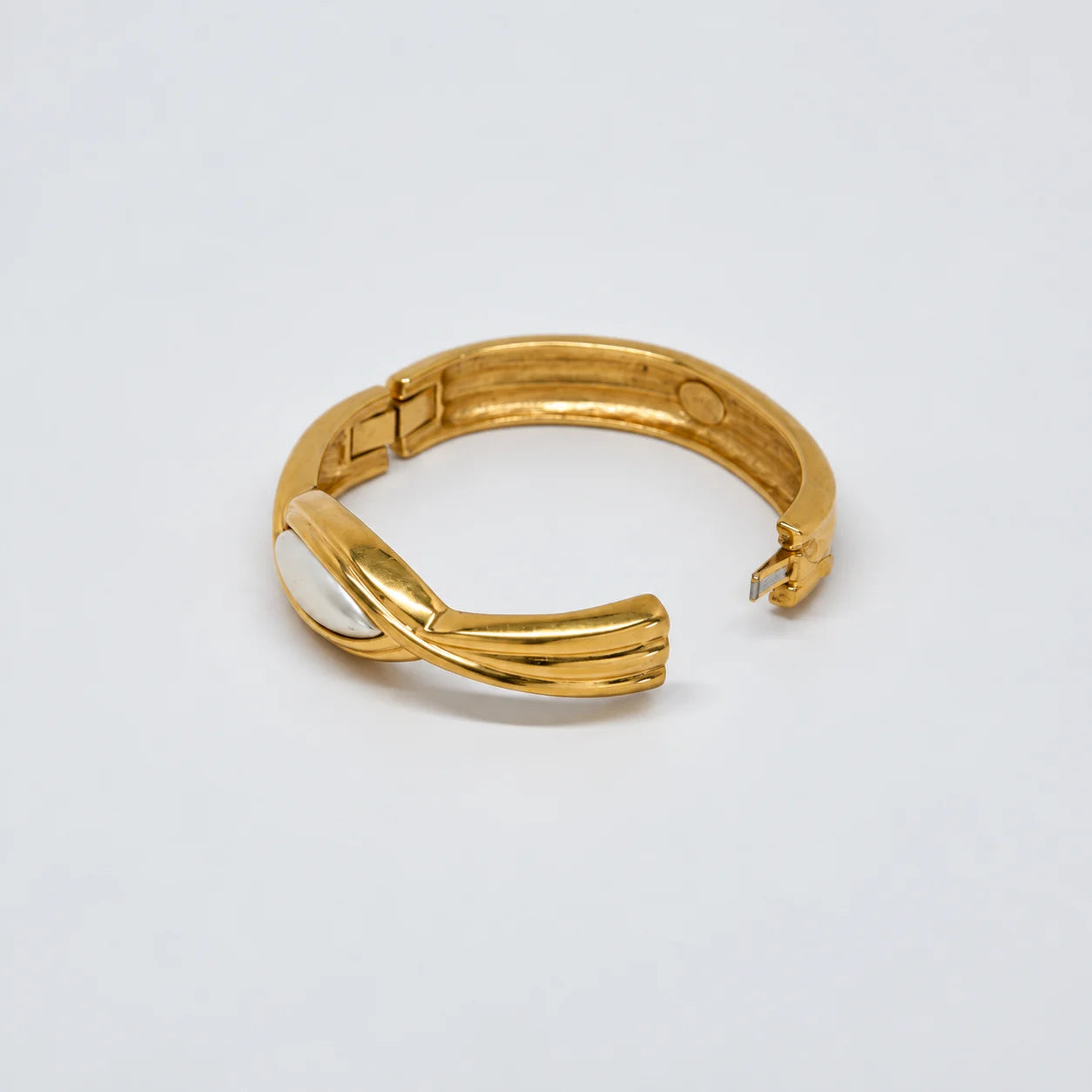 Vintage gold-tone hinged bangle with white oval centerpiece — open clasp