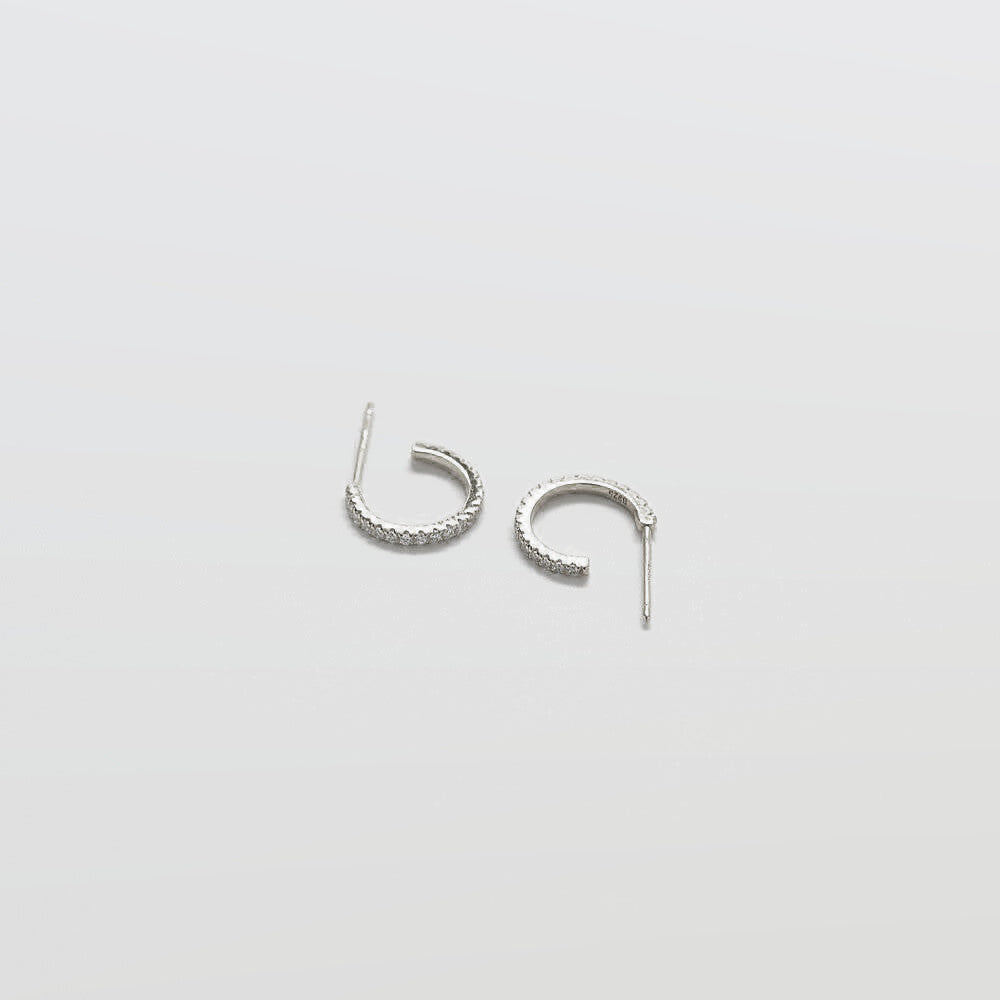 Pair of silver hoop earrings on a light gray background