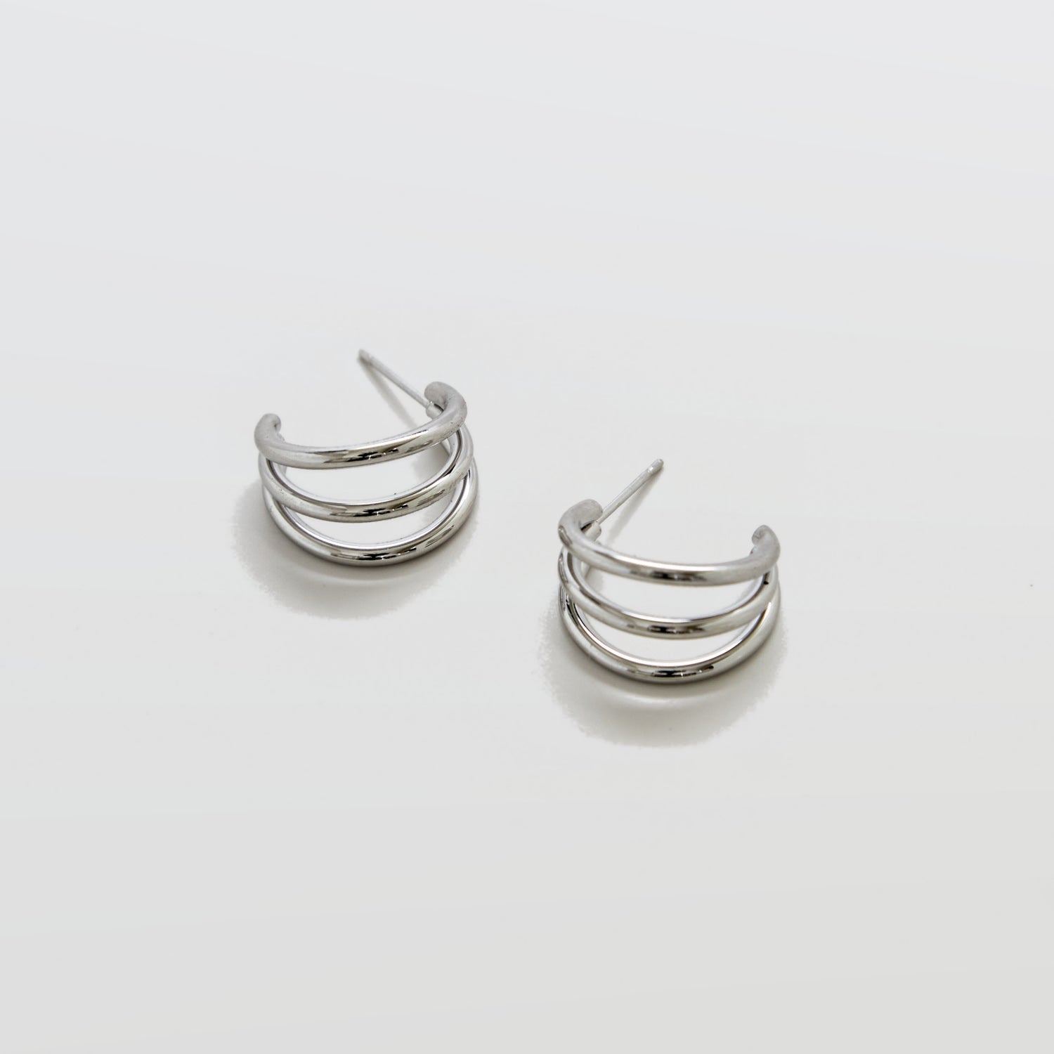 Pair of silver hoop earrings on a light gray background