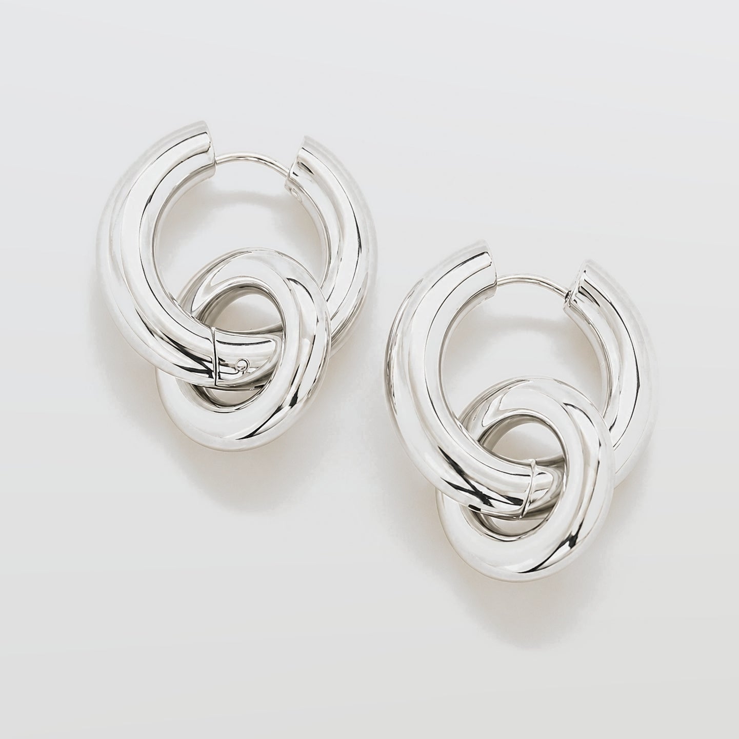 Pair of silver hoop earrings on a light gray background