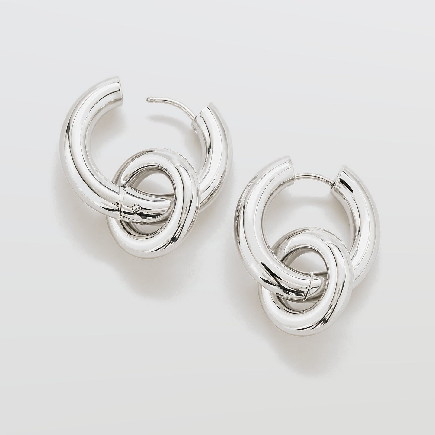 Pair of silver hoop earrings on a light gray background