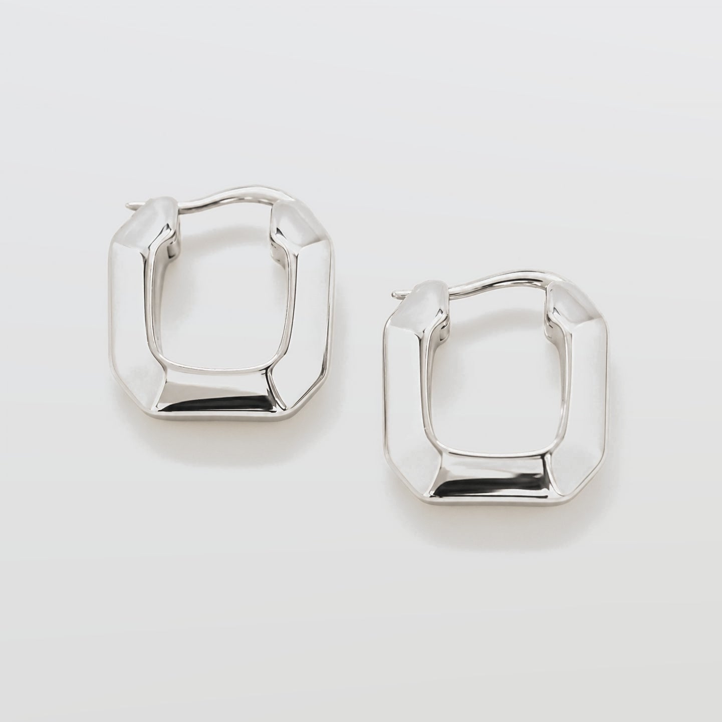 Pair of silver hoop earrings on a light gray background