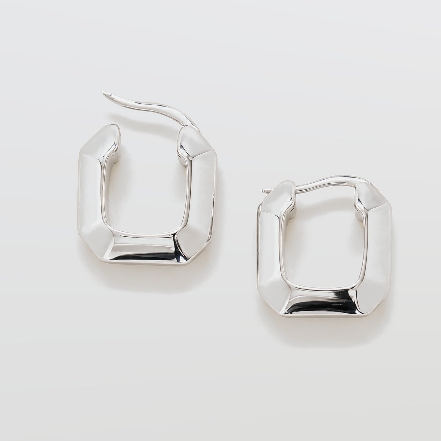 Pair of silver hoop earrings on a light gray background