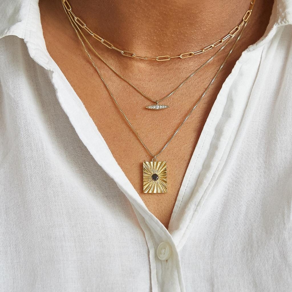 Admiral Row founder wearing layered gold necklaces