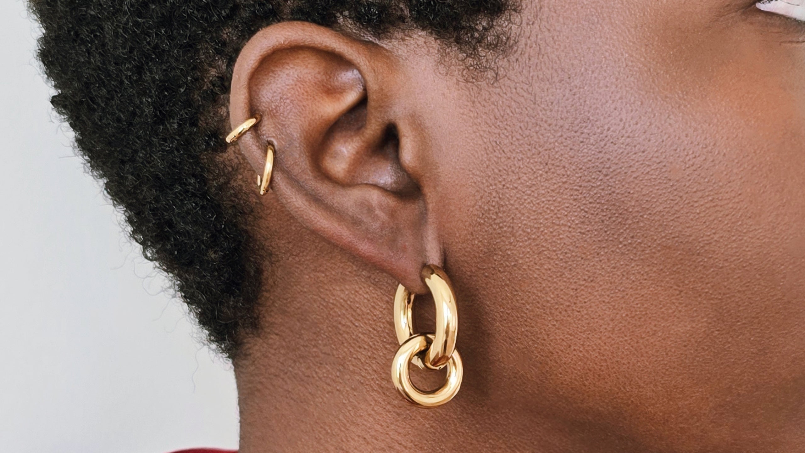 Close-up of layered gold hoop earrings styled on a model