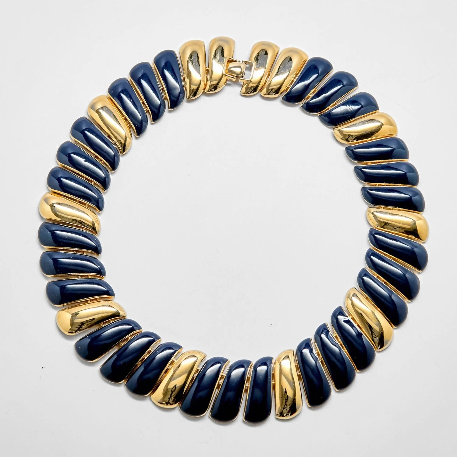 Vintage Monet navy and gold collar necklace on a light gray background