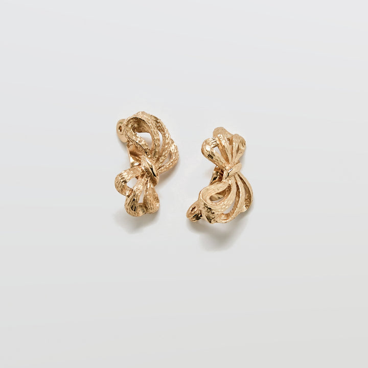 Pair of gold earrings on a light gray background