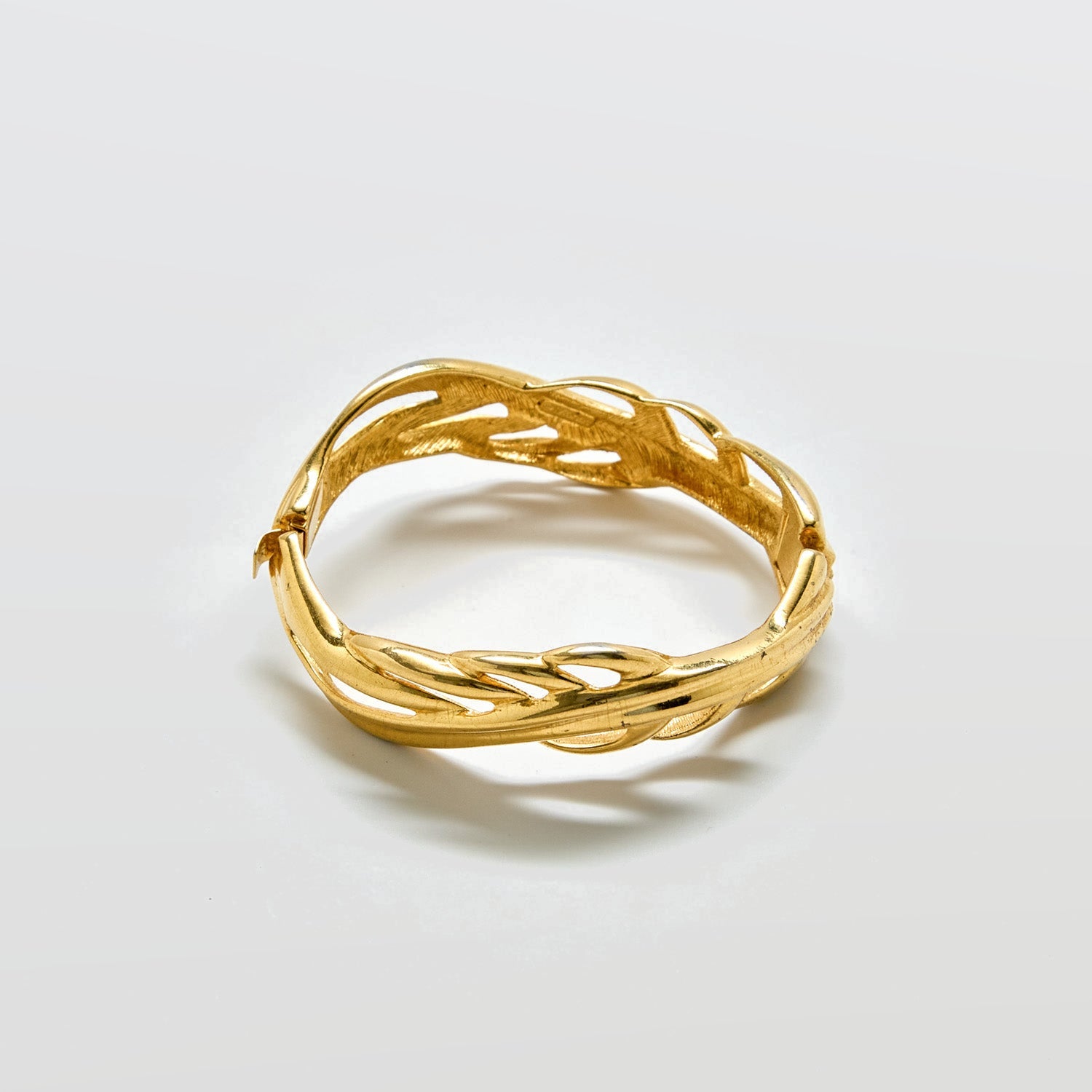 Gold bracelet on a light gray background