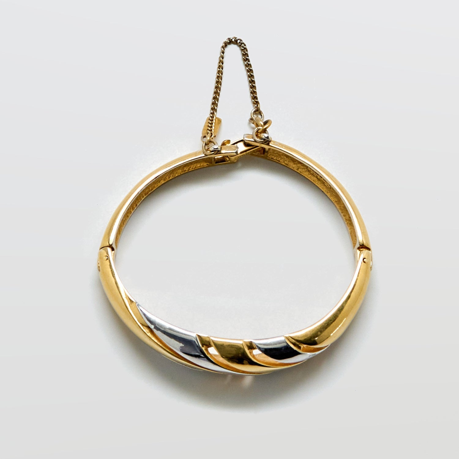 Gold and silver bracelet on a light gray background
