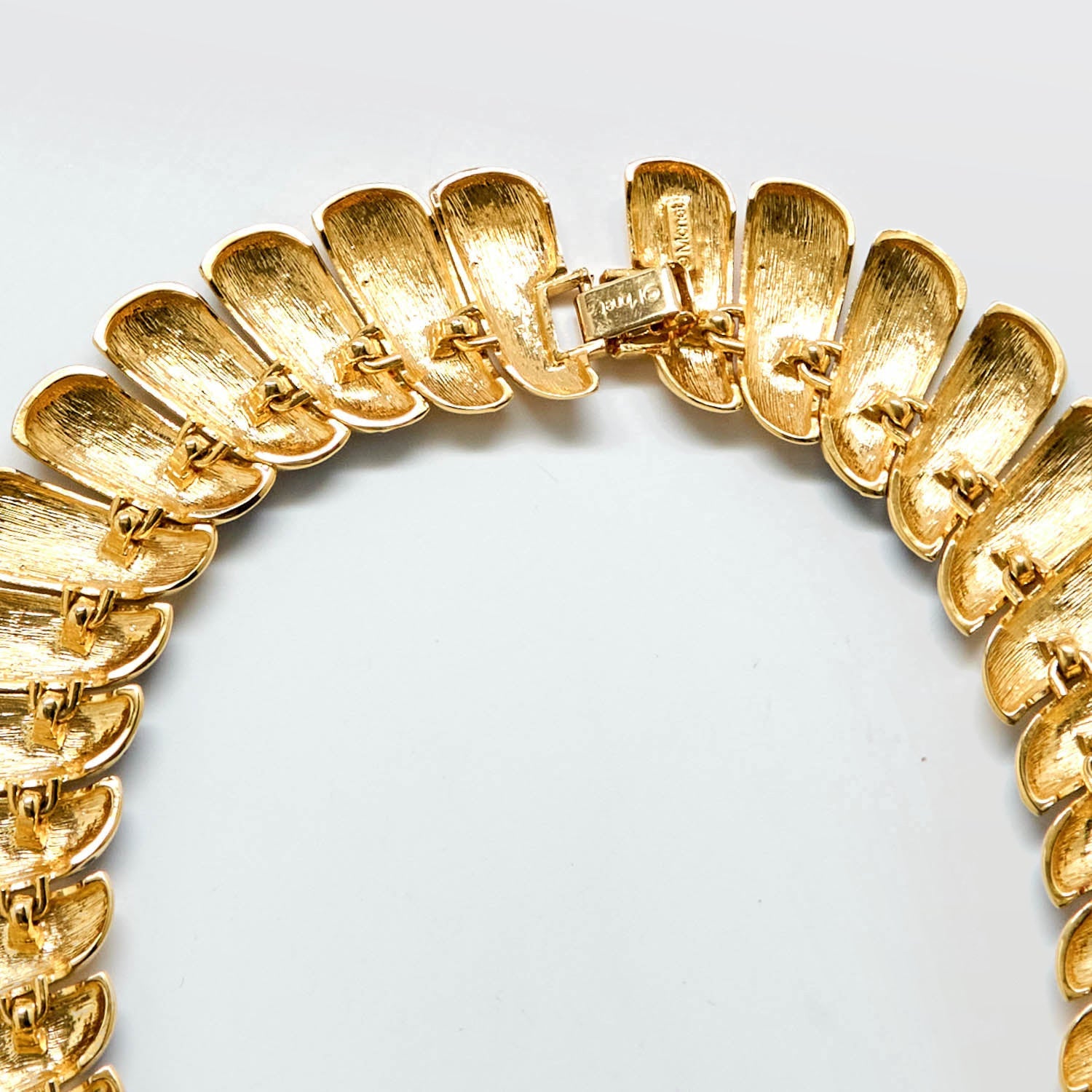 Back of Gold necklace on a light gray background