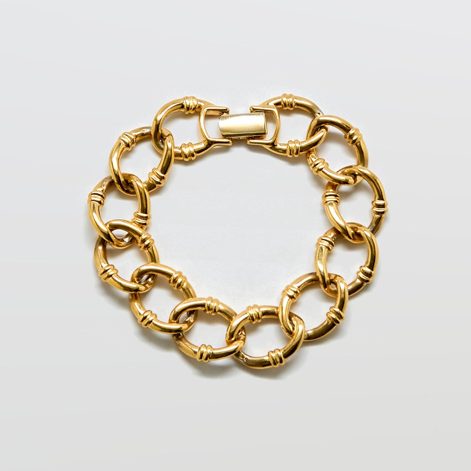 Gold chain bracelet on a light gray background