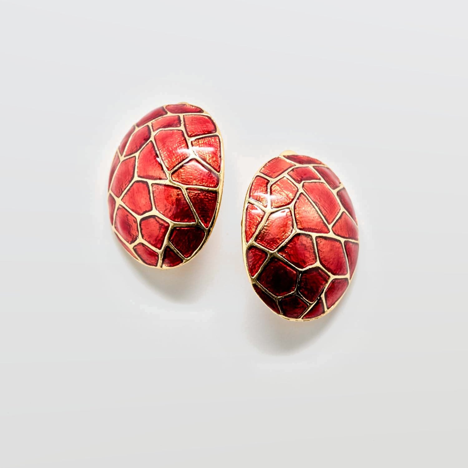 Red patterned earrings on a light gray background