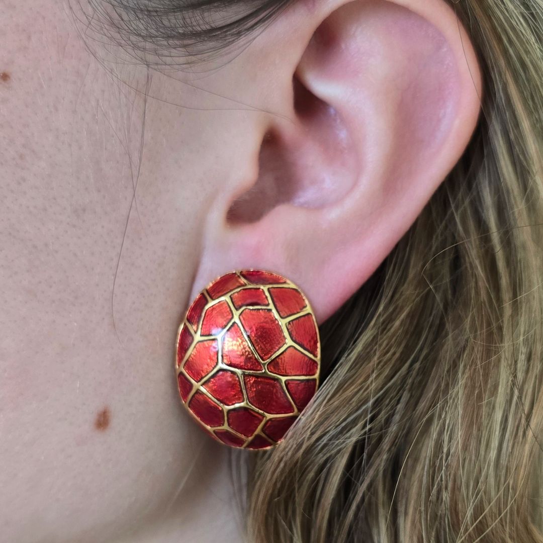 Close-up of a red patterned earring worn by a person.