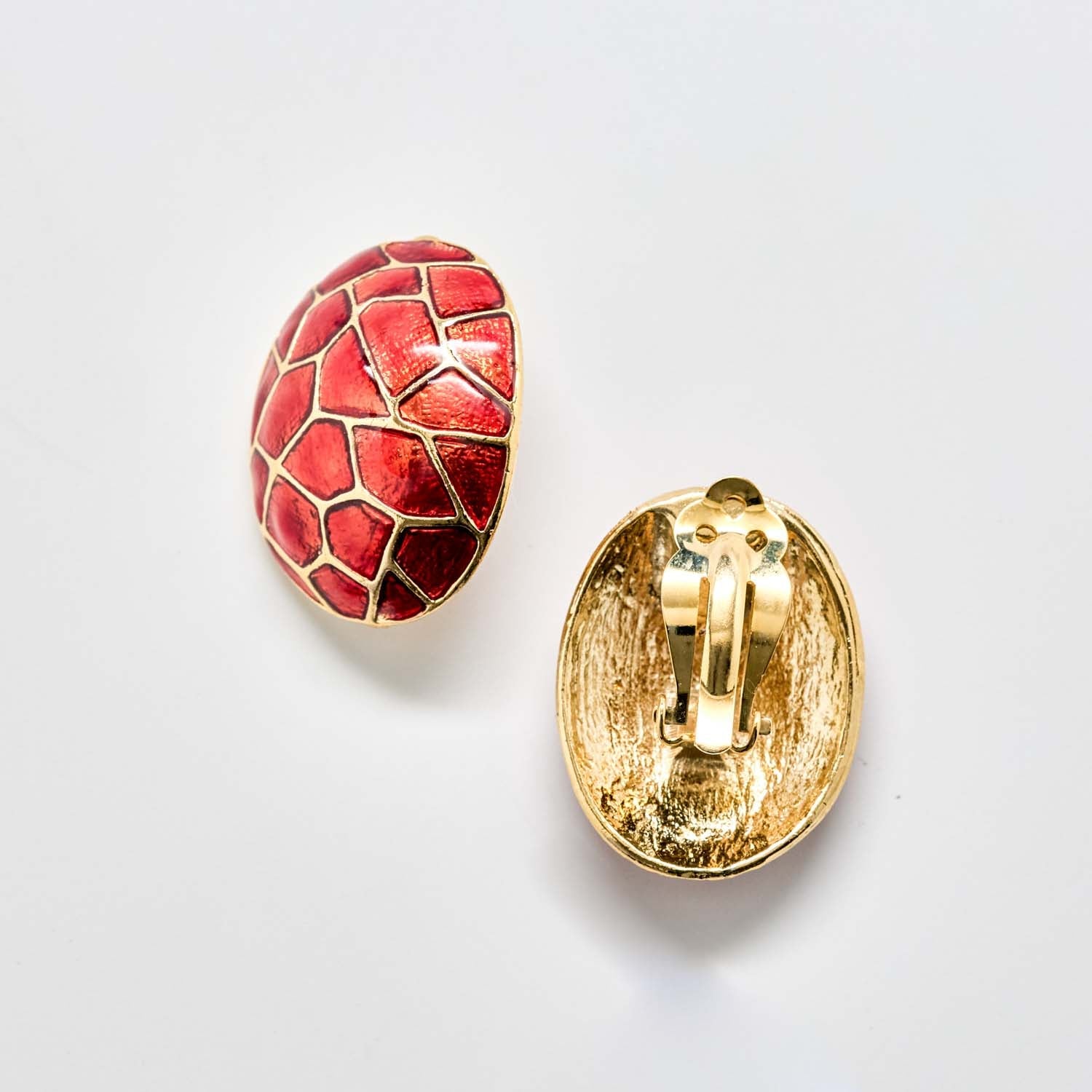 Gold and red earring on a white background